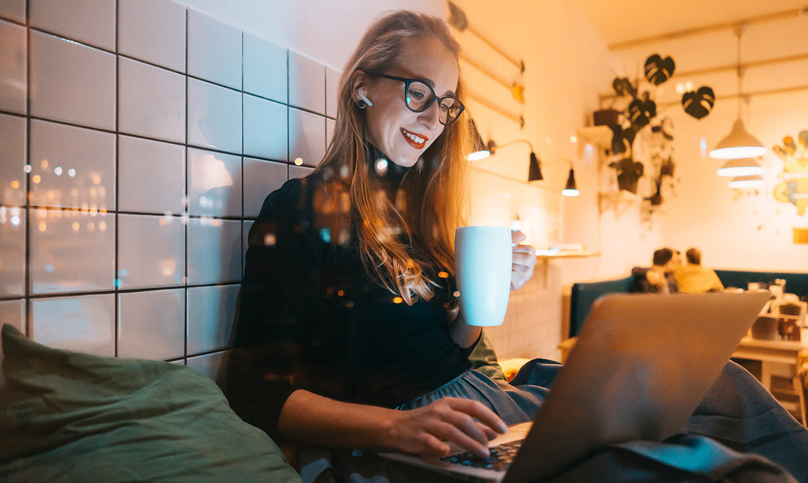 woman with a drink using a computer